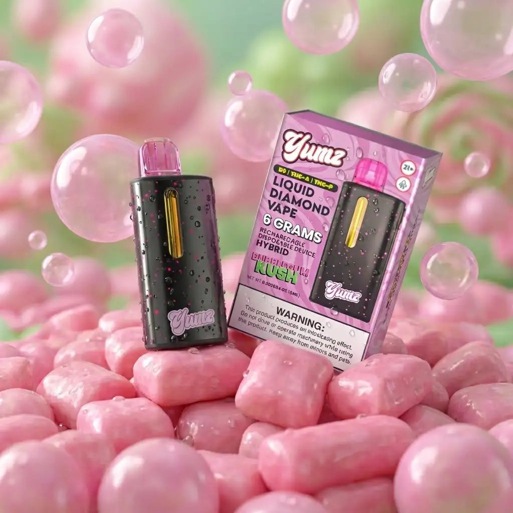 Black and pink yumz liquid diamond vape pen with a gold accent strip, displayed beside its branded packaging.